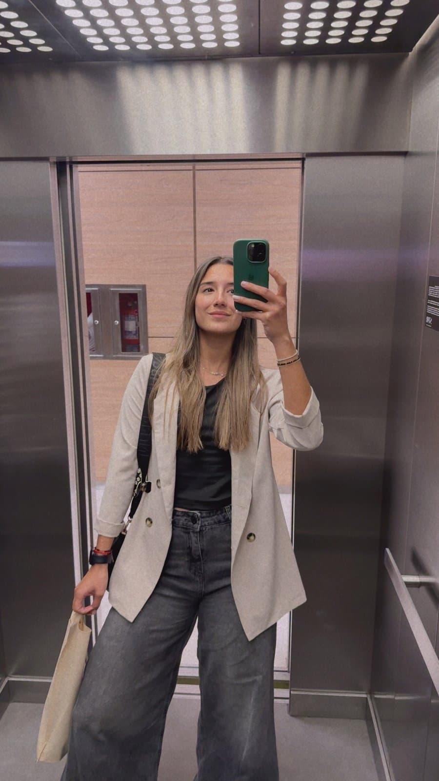 Karen Cattaneo, fundadora de Identity, sacándose una selfie en el espejo de un ascensor